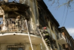 Dos bomberos en la fachada del edificio de la policia en Mariopol, en el que al menos siete prorrusos murieron el viernes