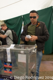 Un hombre con el lazo de San Jorge en su chaqueta se acerca a depositar su voto