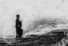 Un joven monje sube la escalera principal del monasterio de Hemis